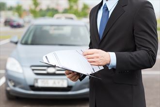 transportation and ownership concept - man with car documents outside